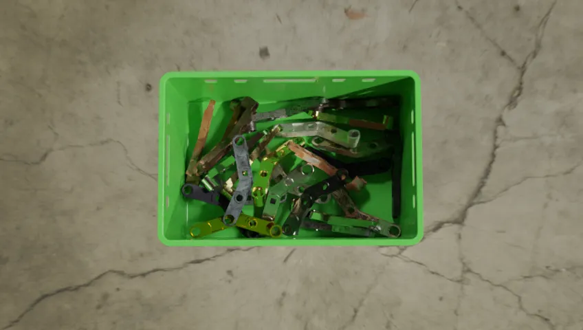 Synthetic render of metallic hinges in a blue industrial bin